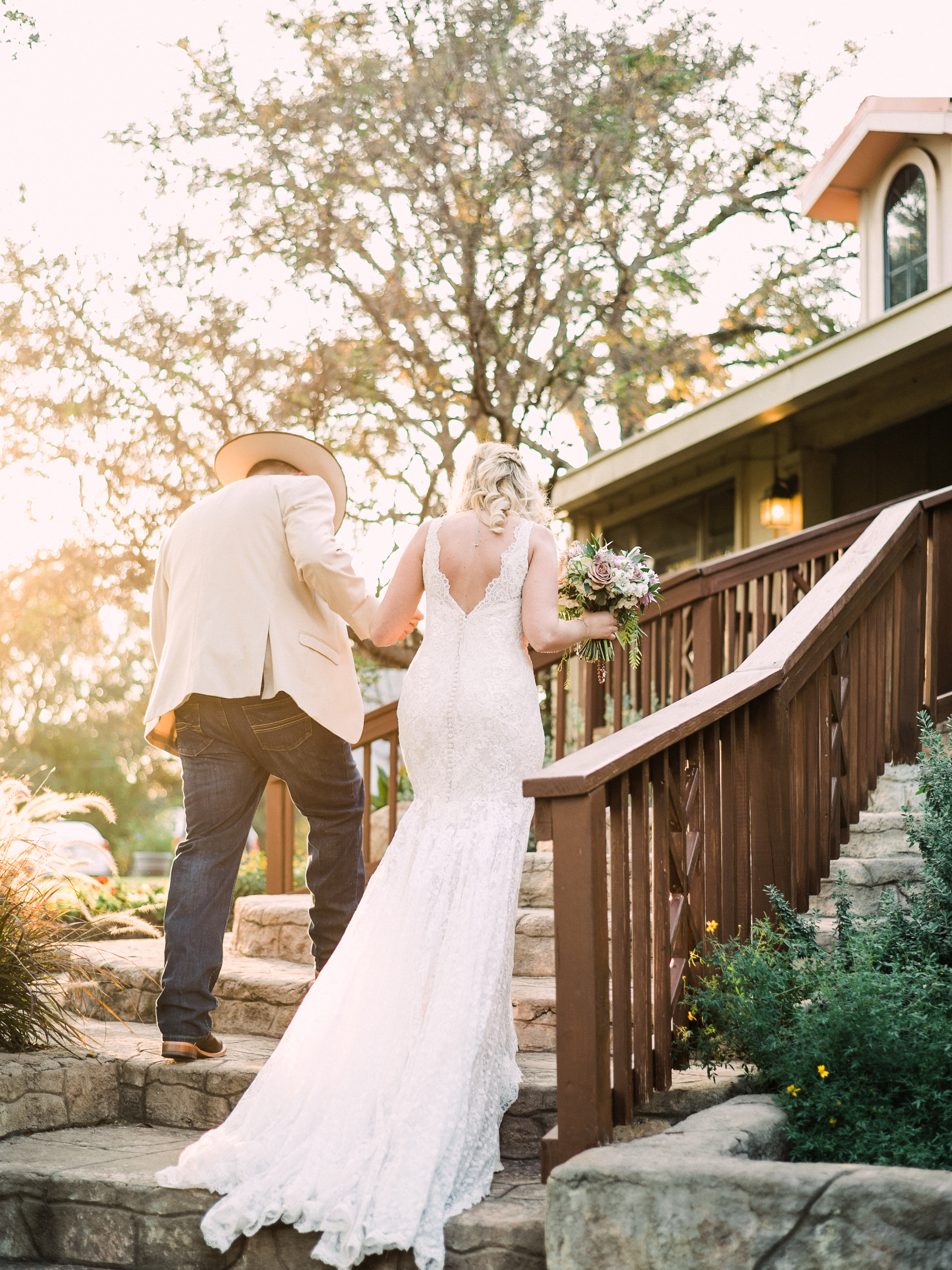 A bride a groom walk back up the aisle after getting married on a sunny day at Kindred Oaks in Georgetown, Texas