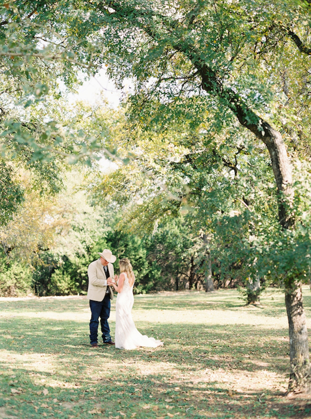 A bride a groom stand together on the grounds of Kindred Oaks, an outdoor wedding venue in Georgetown, Texas.