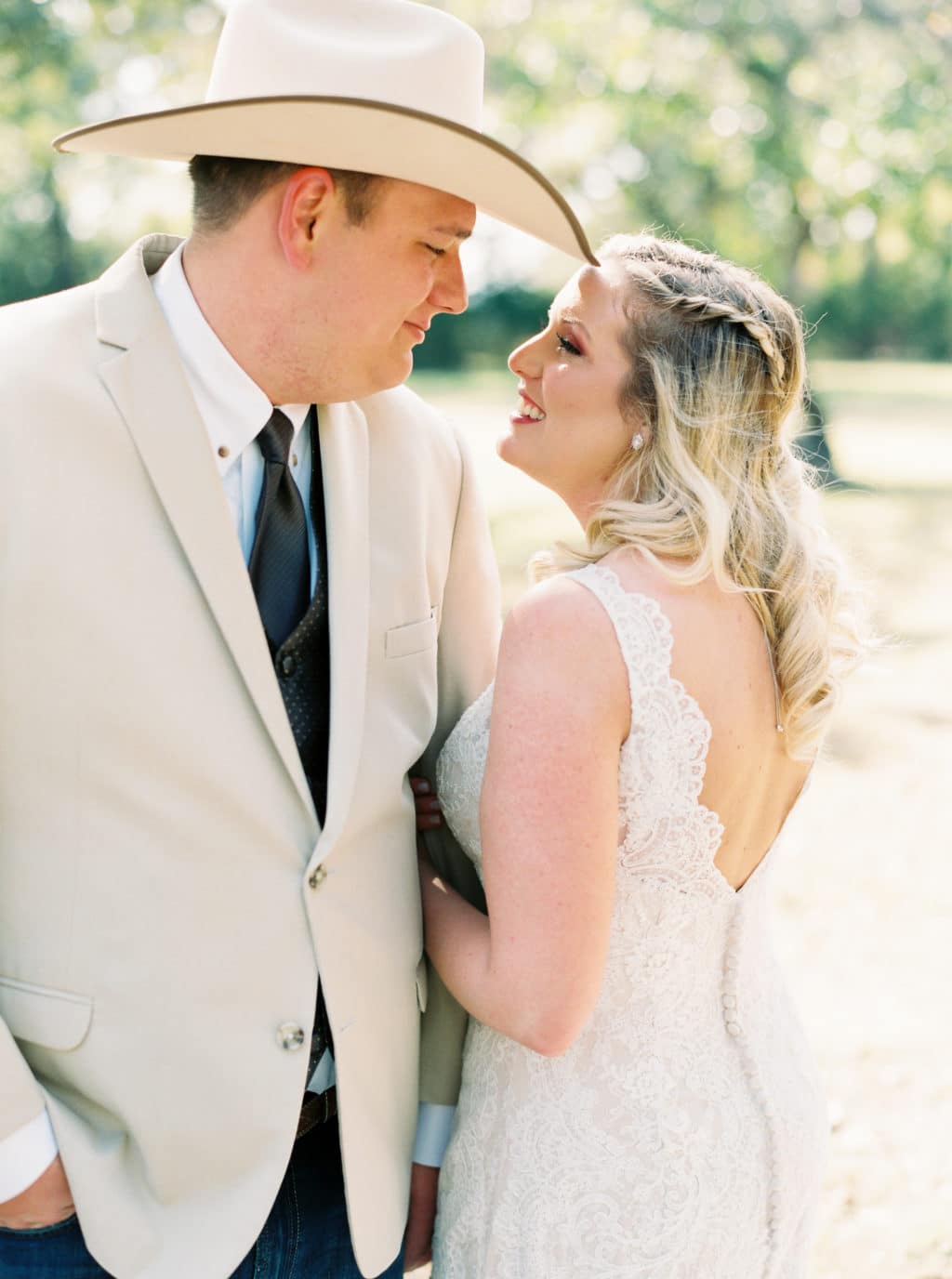 A bride and groom smile at each other as they take wedding portraits at a Georgetown, Texas wedding venue.