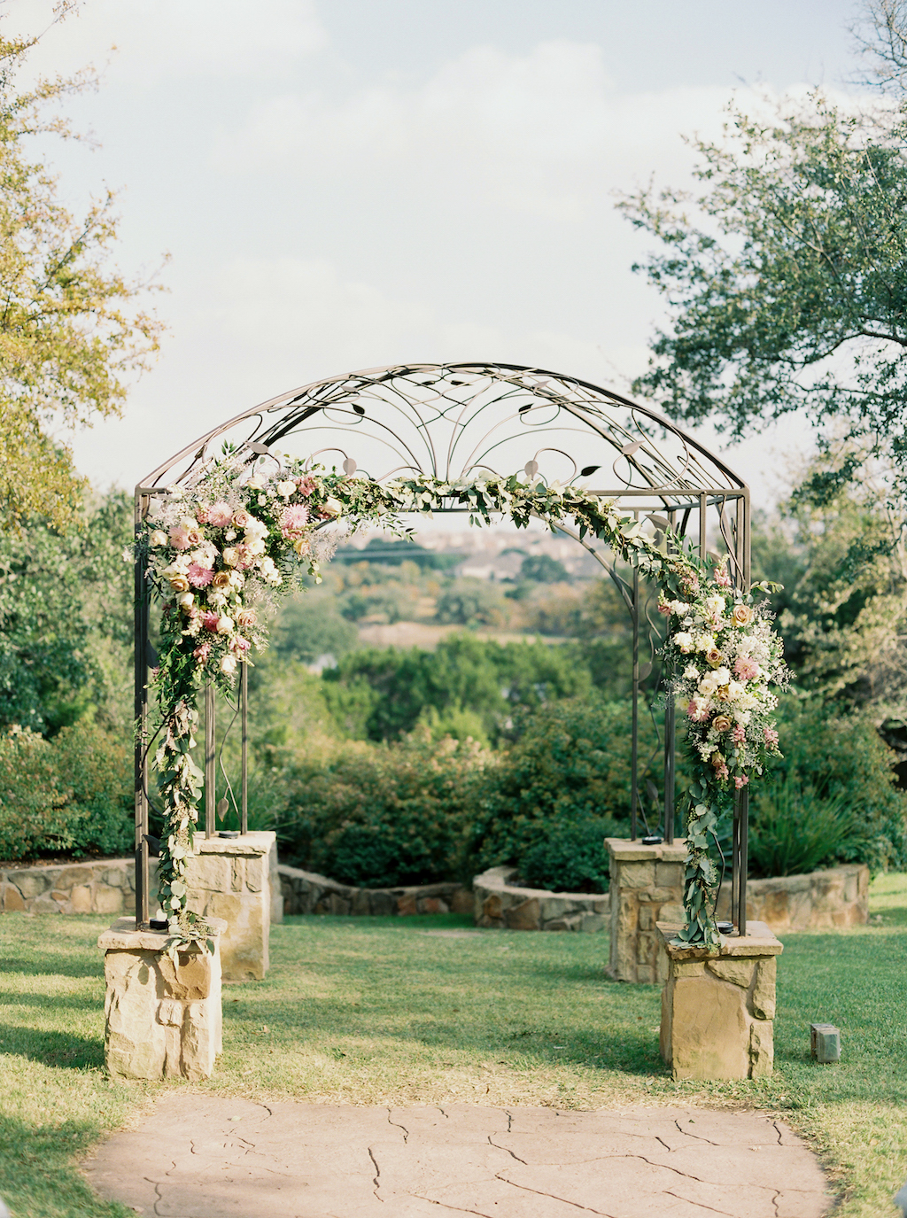 Kindred Oaks, a wedding venue in Georgetown, Texas, features a unique iron arbor at their outdoor ceremony site.